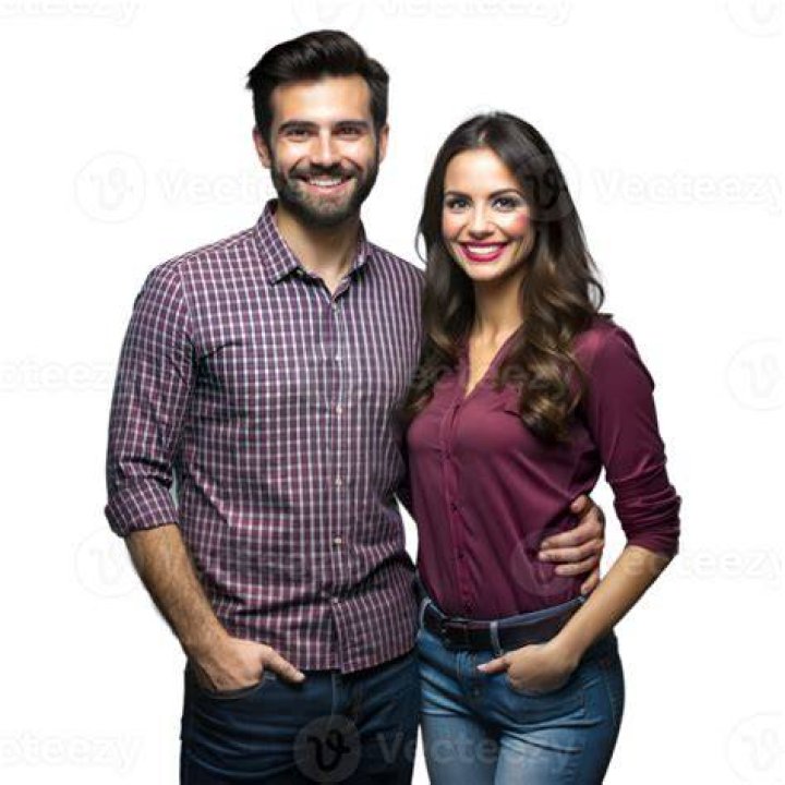 a man and woman standing next to each other in front of a group of people