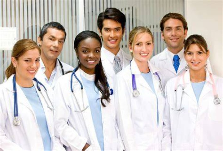 Doctors and medical students stand together while observing a procedure