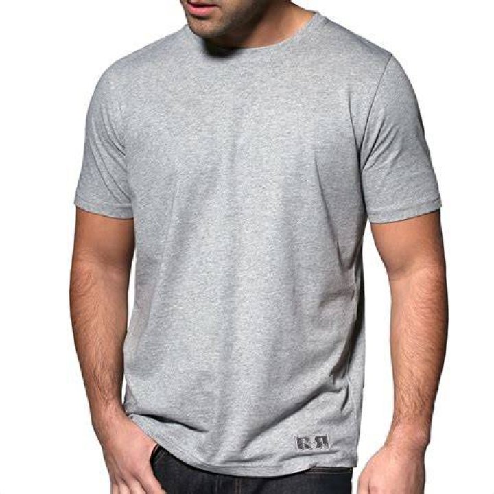 Man in grey t-shirt and red beanie writing on white board