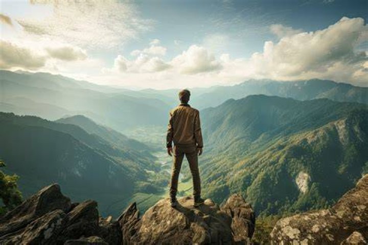 Man standing on a mountain gazing at the horizon