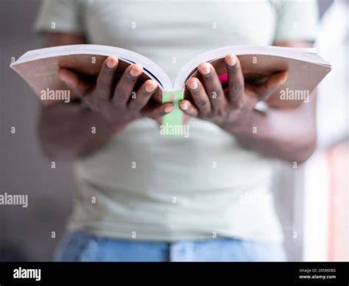 person holding a book over her face