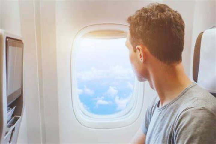 person looking out airplane window