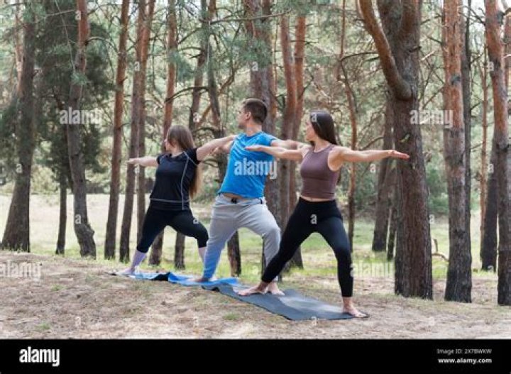 three happy people doing forest clean up on a volunteer abroad trip