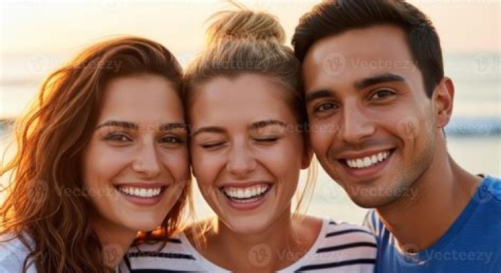 three smiling people arm in arm
